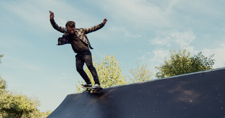 Young male adult skateboarding halfpipe miniramp grinding and makes tricks