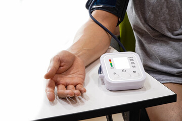 Monitoring blood pressure of patients using upper arm blood pressure monitor in the clinic examination room.	
