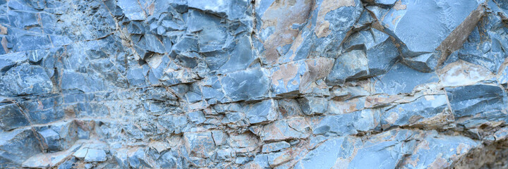 the texture of the surface of the gray blue natural stone rocks as a background. banner