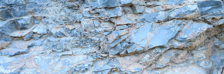 the texture of the surface of the gray blue natural stone rocks as a background. banner