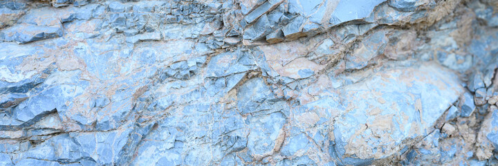 Fototapeta premium the texture of the surface of the gray blue natural stone rocks as a background. banner