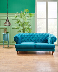 Green living room, classic wall background with blue sofa and lamp with vase of plant.