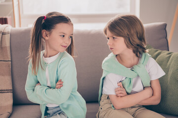 Photo portrait of small children having argument quarrel with each other folded hands