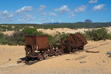 Rusty mining carts at beach of Spiaggia di Piscinas, Sardinia, Italy