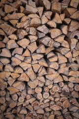 Wooden background in the form of chopped and stacked logs. Wooden texture. 