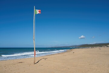 Italian flag at beach of Spiaggia di Piscinas