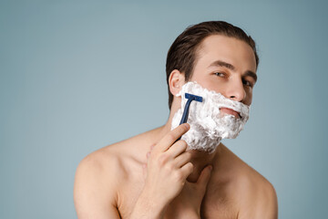 Attractive young smiling nude man with shaving foam