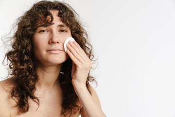 Half-naked curly woman posing and using cotton pad © Drobot Dean
