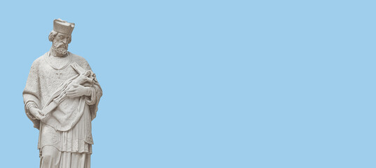 Banner with a statue of priest with figure of crucified Jesus in Vienna historical downtown at blue sky background with copy space, Austria. Concept of Cultural and Religious Heritage and Travel.