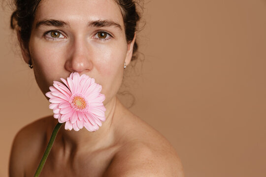 Half-naked european woman posing with pink flower