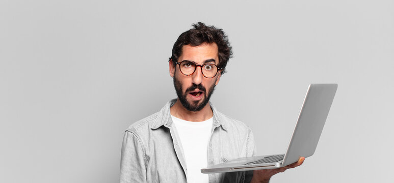 young crazy bearded man afraid or confused expression. laptop concept