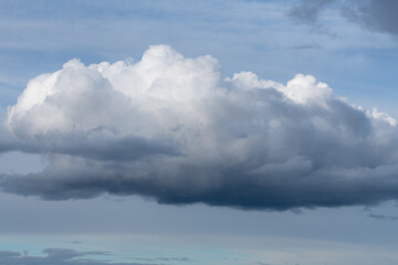Fototapeta na wymiar Big white and gray fluffy cloud in the sky