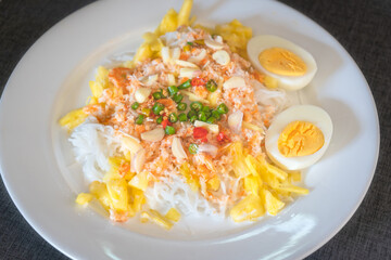 Thai rice noodles with pineapple and coconut milk the delicious of traditional food served on white plate in Thai name is Kanom Cheen Saw Num.