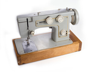 Old electric sewing machine on a white