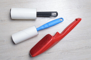 brushes for cleaning clothes. sticky and a bristled brush, lie on a light-colored countertop.