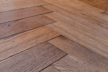Low angle photo of orange brown aged old hundred year old hardwood oak parquet tile floor of...