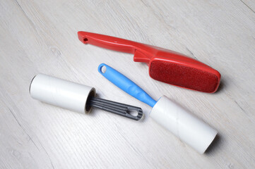 brushes for cleaning clothes. sticky and a bristled brush, lie on a light-colored countertop.