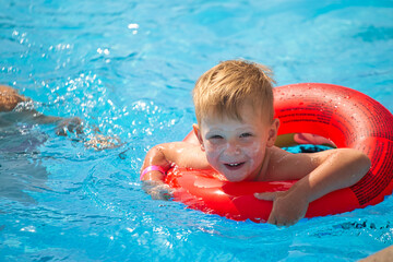 children swim in a pool with blue water