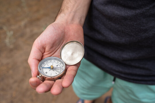 Young man looking for direction on the compass.