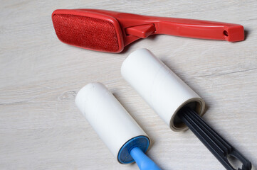 brushes for cleaning clothes. sticky and a bristled brush, lie on a light-colored countertop.