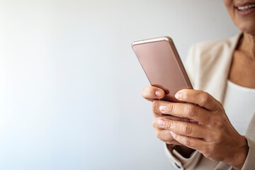 Entrepreneur working on her phone at the office. Close-up of an unrecognizable woman using smart phone. Cropped shot of a businesswoman using a mobile phone in a modern office