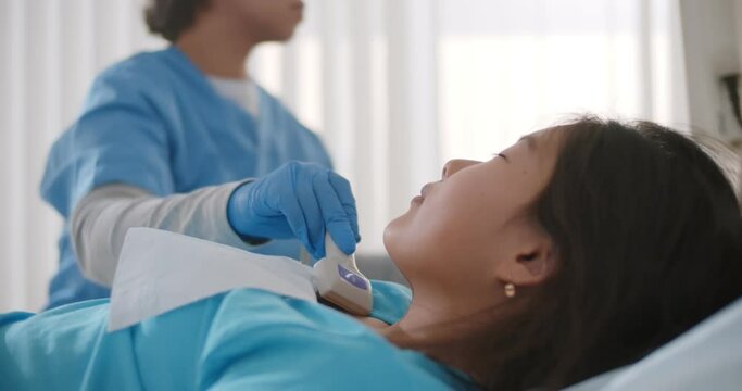 Woman doctor examining patient child girl thyroid gland using ultrasound scanner machine