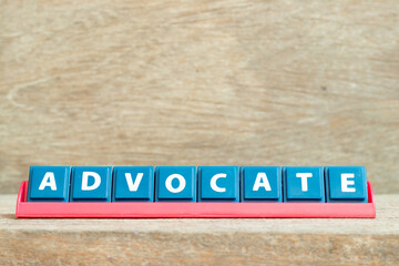 Obraz premium Tile alphabet letter with word advocate in red color rack on wood background