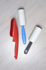 brushes for cleaning clothes. sticky and a bristled brush, lie on a light-colored countertop.