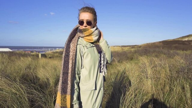 Slow Motion Beauty Shot of Stulish Young Girl in Scarf Staying in High Grass. Spring of Autumn Weather in Netherlands