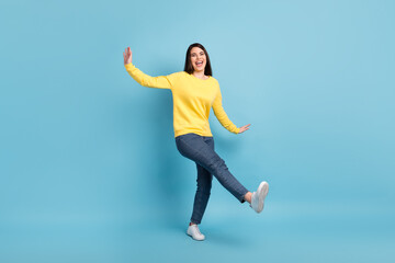 Fototapeta na wymiar Photo of funky lovely lady dance raise hands open mouth wear yellow jumper jeans sneakers isolated blue background