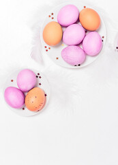 Fototapeta na wymiar Colored eggs on plate with on white background. Flat lay. Copy space. Easter concept. Top view.