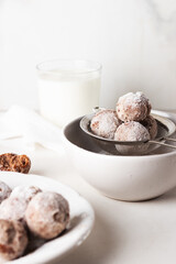 Homemade cottage cheese donuts balls with powdered sugar in a bowl on a light background. Beautiful breakfast. 