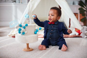 cute one year old baby boy having a home party with birthday cake - 419871246