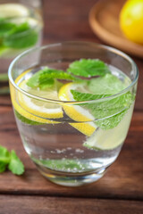 Tasty refreshing lemonade on wooden table, closeup. Summer drink