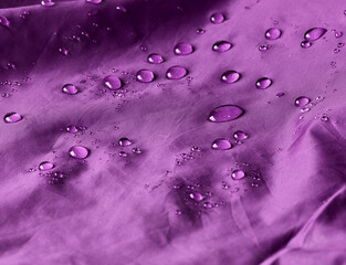 Water drops on waterproof membrane fabric. Detail view of texture of olive waterproof cloth.