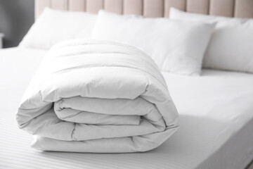 Fototapeta na wymiar Soft folded blanket on bed at home