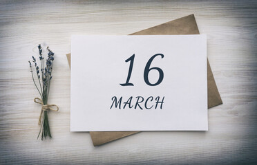 march 16. 16th day of the month, calendar date. White blank of paper with a brown envelope, dry bouquet of lavender flowers on a wooden background. Spring month, day of the year concept