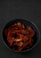 fried bacon on black surface