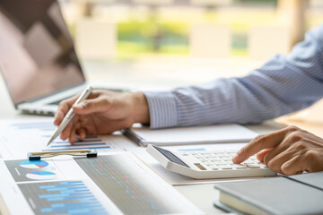 close-up of a male accountant or banker who notes and checks investment results, calculates...