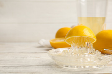 Freshly squeezed lemon juice on white wooden table. Space for text