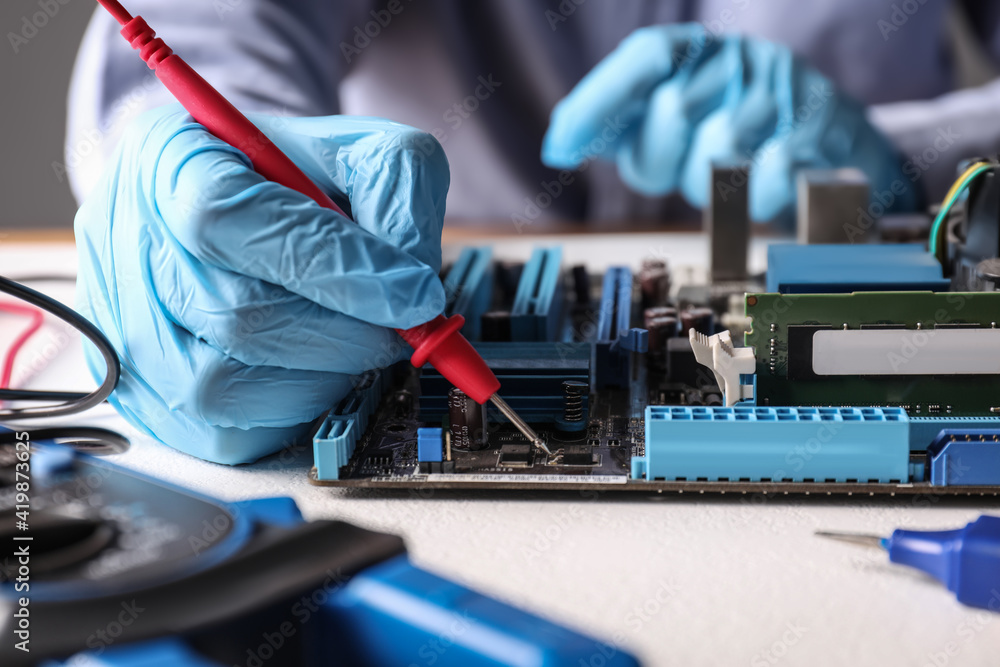 Wall mural Technician repairing electronic circuit board at table, closeup