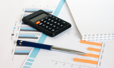 Profit bar chart, pen, notepad and calculator