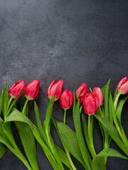 pink tulips on black stone surface