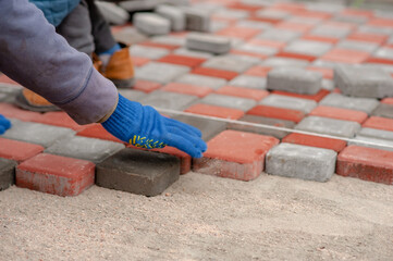 Bricklayer laying paving slabs. Paving stones for laying paths