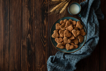 Top view on homemade wholegrain cookies with oatmeal, raisin, nuts, seeds and milk on brown rustic wooden background. Healthy eating concept.  Copy space