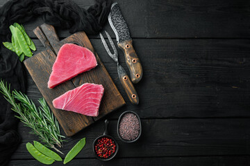 Raw tuna fillet. Seafood with sugar green pea, sesame and ingredients, on wooden cutting board, on black wooden background, top view flat lay , with copyspace  and space for text