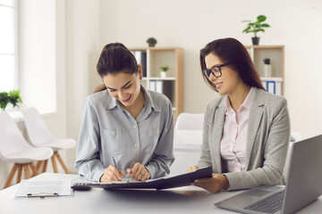 Document contract agreement after successful negotiation or hiring interview. Young woman applicant writing signature. Lawyer and client signing paper loan insurance during meeting in office