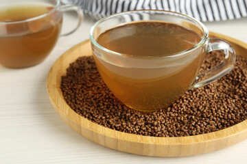 Delicious buckwheat tea and granules on white wooden table