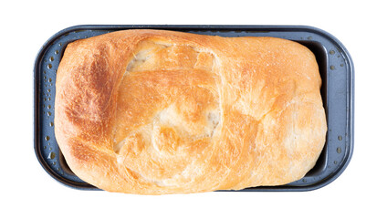 Overhead view of a small loaf of homemade bread in a metal pan isolated on a white background.