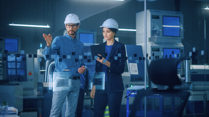 Modern Factory: Female Project Manager, Male Engineer Standing in High Tech Development Facility, Talking and Using Tablet Computer. Contemporary Facility with CNC Machinery, Robot Arm Production Line